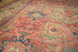 Worn cinnabar red antique Mahal carpet with navy blue palmettes, green accents, and foundation showing.