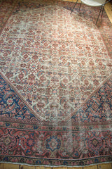 Worn red border with intricate navy spandrel and Herati pattern on an antique Mahal carpet.