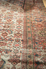 Antique Mahal carpet's herati motif, patterned border, and visible wear to knot heads.