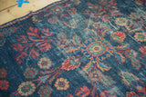 Distressed indigo field of a Vintage Mahal rug with vibrant floral bouquets and worn foundation.