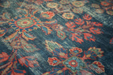 Distressed vintage Mahal rug pile with visible foundation, showing indigo, red, and green floral motifs.