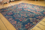 Distressed indigo field of a vintage Mahal rug, revealing allover blush and green floral bouquets.