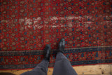 Vintage Malayer rug with rust red field, indigo blue boteh design, and visible distress.