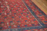Worn rust red vintage Malayer rug with indigo paisley boteh, vinery, and blue border.