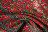 Rust red vintage Malayer rug detail with folded pile, geometric boteh, and distressed texture.