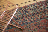 Intricate Laleh Abassi pawn motifs on an antique Malayer rug in rose and navy.