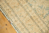 Vintage Pak Kazak rug's mellow beige pile, blue stripes, and frayed selvage.
