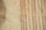 Kurdish throw rug's central seam, natural brown bands, and faded orange color migration.