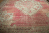 Etched low pile texture on the blush field and sea foam spandrel of a vintage Oushak carpet.