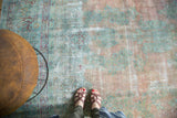 Vintage Kerman rug's faded blush and sea foam floral Safavid pattern with visible foundation wear.