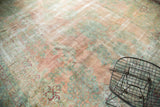 Faded blush rose and sea foam floral design on vintage Kerman carpet showing visible foundation.
