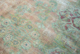 Vintage Kerman carpet detail: Muted floral motifs in pale blush, sea foam, and visible foundation.