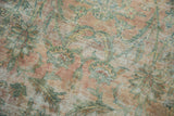 Antique Kerman rug detail, worn blush, green, ivory floral pattern, visible foundation.
