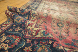 Faded cranberry field and dark indigo border on antique Yazd rug showing floral vinery.