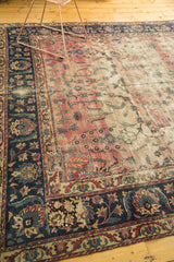 Antique Yazd with faded cranberry floral field, indigo border, and visible etching and patches.