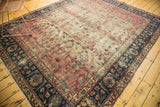 Antique Yazd carpet corner: dark indigo border, potted plants, faded cranberry field, areas of patches.