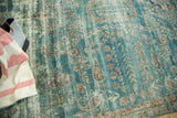 Faded teal antique Kerman carpet displays even wear, European-influenced floral, and paisley motifs.