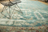 Even wear reveals foundation through sky blue field of antique Kerman carpet.