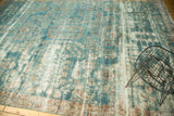 Antique Kerman carpet's pile showing even wear, visible foundation, muted blue, ivory floral motifs.