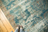 Antique Kerman carpet showing even wear, faded teal, wine red patterns underfoot.