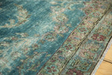 Faded teal and plum floral border of antique Kerman carpet, showing even pile wear.