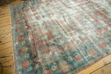 Heavy areas of distress on a vintage Mahal carpet, with faded raspberry and sky blue scrolling patterns.
