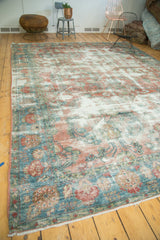 Distressed vintage Mahal carpet corner featuring faded teal, dusty rose, and ivory tones.