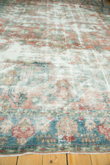 Heavily distressed vintage Mahal carpet showing faded raspberry red and sky blue motifs.
