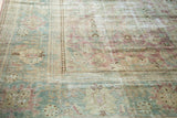 Malayer carpet corner, rhythmic brown border, faded pastel florals, mostly even wear.