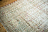 Vintage Malayer rug with worn pile, visible foundation, and faded floral motifs.