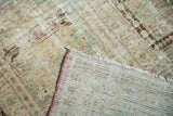 Vintage Malayer carpet folded, displaying its woven foundation, fringe, and worn pile.
