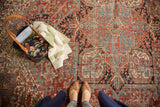 Vintage Heriz rug close-up showing rectilinear geometric pattern, brick red, navy, short pile.