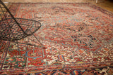 Rectilinear patterns and short pile on a vintage Heriz carpet in brick red and navy.