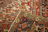 Heriz style rug corner detail showing rectilinear design, fringe, and navy border.
