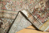 Antique Fereghan rug's folded corner displaying hand-knotted foundation, secure side, and faded Herati pattern.
