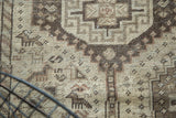 Vintage Qashqai rug with geometric animal motifs in antique ivory, pale wooded, and rich brown tones.