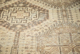 Geometric motifs in pale ivory and wooded tones with even wear on a vintage Qashqai rug.