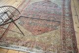 Antique Malayer rug corner detailing even distress, finished fringe, and faded Herati motif.