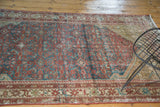Distressed antique Malayer rug showing Herati motif field and detailed patterned border.