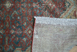 Antique Malayer rug's hand-knotted foundation, restored ends, and faded brick red Herati motif.
