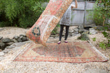 Distressed antique Malayer rug showcasing allover Herati pattern and subtle brick and saffron tones.