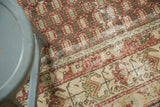 Antique Hamadan rug detail: repeating brick red boteh and muted copper green flowers with softened pile.