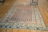 Antique Hamadan rug corner, ivory germinating flower border, brick red boteh, visible foundation wear.