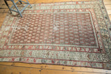 Worn antique Hamadan rug corner, revealing brick red germinating floral border details.
