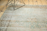 Vintage Tabriz rug corner displaying faded charcoal border and sea foam green trefoil motifs.