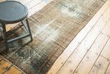 Vintage Malayer runner's distressed end, featuring geometric motifs in beige, bronze, and mint green.