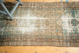 Vintage Malayer runner with geometric motifs in beige, brown, oxidized green, and visible foundation wear.