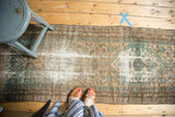 Vintage Malayer runner showing areas of worn pile, exposed foundation, and muted floral motifs.