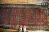 Vintage Malayer runner showing madder root red field with germinating flowers and beige border.