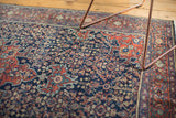 Finely woven henna plant motifs and border pattern in madder red, navy, and green.